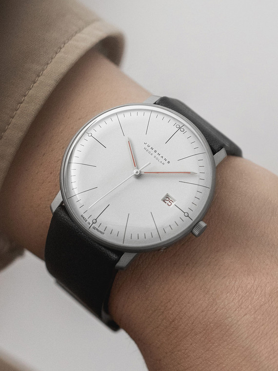 The Junghans Max Bill Mega Solar Bauhaus 59/2326.02 is a watch with a clean, timeless look inspired by the Bauhaus artistic style. It features a domed white solar dial with luminous dots and baton indices. The dial has a precise second display in half-second motions with silver hour, minute, and second hands. The watch also has a radio-controlled movement.