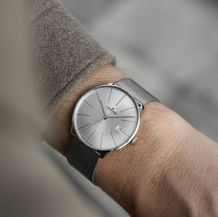 The Junghans Meister Fein Automatic Steel watch is a minimalist unisex model that is fully silver in color. It has a stainless steel Milanese bracelet with a safety buckle, a domed sapphire crystal with an anti-reflective coating on both sides, and is water resistant to 5 bar (50 m). It has a stainless steel case, a silver-plated dial with a sunray brush, and an automatic movement. The watch is made in Germany.
